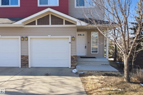 Exterior facade featuring light-toned siding, stone accents, and a contrasting upper level with red siding - 19 15151 43 Street, Edmonton, AB - Outdoor