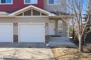 Exterior facade featuring light-toned siding, stone accents, and a contrasting upper level with red siding - 19 15151 43 Street, Edmonton, AB  - Outdoor 