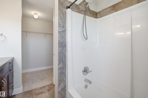 Bathtub with a white acrylic surround and chrome fixtures - 19 15151 43 Street, Edmonton, AB - Indoor Photo Showing Bathroom