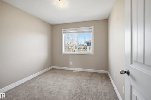 Neutral-toned interior with light tan walls, white trim, and gray carpet flooring - 19 15151 43 Street, Edmonton, AB - Indoor Photo Showing Other Room