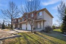 Multi-story duplex featuring neutral siding, a stone facade accent, and an attached two-car garage - 19 15151 43 Street, Edmonton, AB  - Outdoor With Facade 