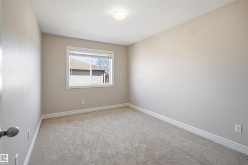 Interior room with neutral-toned walls, light-colored carpeting, a single window, white trim, and a ceiling-mounted light fixture - 19 15151 43 Street, Edmonton, AB - Indoor Photo Showing Other Room