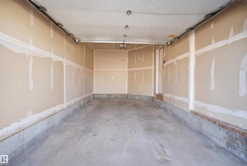 Two-car garage with concrete flooring, drywall-finished walls, and ceiling-mounted track for garage door - 19 15151 43 Street, Edmonton, AB - Indoor Photo Showing Garage