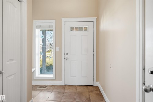 Entryway featuring tiled flooring, a white paneled entry door with transom lites, and a sidelite window - 19 15151 43 Street, Edmonton, AB - Indoor Photo Showing Other Room