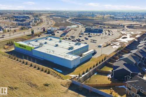 Commercial property featuring a large grocery store with a prominent "Fresh Co" sign, extensive paved parking, and multiple commercial buildings - 19 15151 43 Street, Edmonton, AB - Outdoor With View