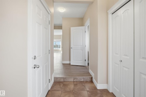 Entryway featuring brown-toned tile flooring, light neutral wall paint, and white trim - 19 15151 43 Street, Edmonton, AB - Indoor Photo Showing Other Room