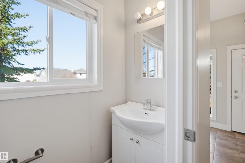 White vanity with integrated sink and chrome faucet - 19 15151 43 Street, Edmonton, AB - Indoor Photo Showing Bathroom