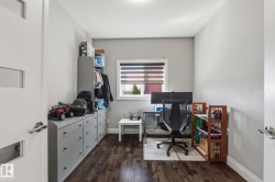 Dedicated workspace featuring wood-finish flooring, a window with horizontal blinds, and recessed ceiling lighting - 