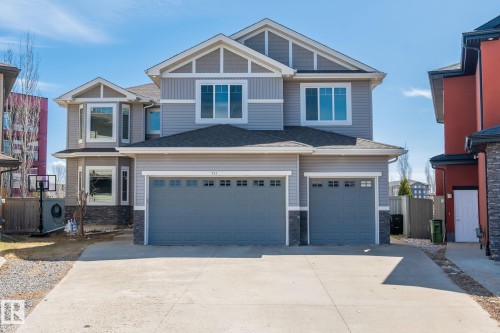 Two-story residence featuring light gray siding, dark gray garage doors, and stone accents - 731 57 Street Sw, Edmonton, AB - Outdoor With Facade