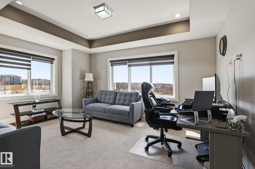 Room featuring a tray ceiling with recessed lighting and a central flush-mount fixture - 731 57 Street Sw, Edmonton, AB - Indoor