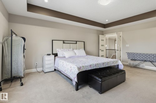 Tray ceiling with recessed lighting and a central flush-mount fixture - 731 57 Street Sw, Edmonton, AB - Indoor Photo Showing Bedroom