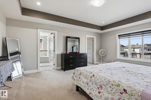 Spacious room featuring carpet flooring and a tray ceiling with recessed lighting - 731 57 Street Sw, Edmonton, AB - Indoor Photo Showing Bedroom