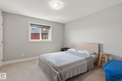 Bedroom featuring neutral wall paint, light-toned carpeting, and a single window with blinds - 