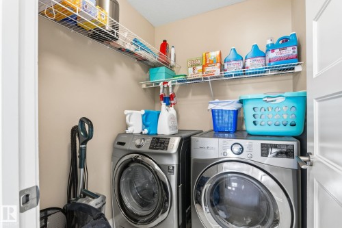 Dedicated laundry area featuring dual wire shelving and neutral wall tones - 731 57 Street Sw, Edmonton, AB - Indoor Photo Showing Laundry Room