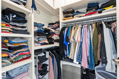 Integrated closet system featuring white shelving and chrome hanging rods - 731 57 Street Sw, Edmonton, AB - Indoor With Storage