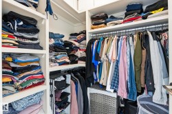Integrated closet system featuring white shelving and chrome hanging rods - 