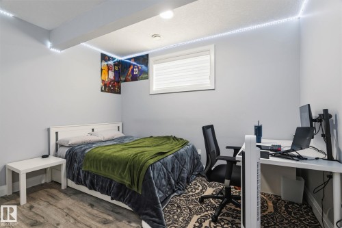 Spacious room featuring wood-finish flooring, a contemporary window with blinds, recessed ceiling lighting, and light gray wall paint - 731 57 Street Sw, Edmonton, AB - Indoor Photo Showing Bedroom