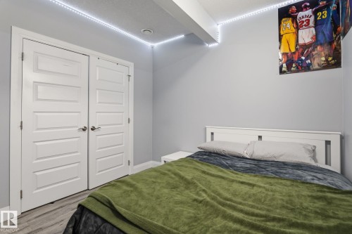 Bedroom featuring light gray walls, wood-finish flooring, and white trim - 731 57 Street Sw, Edmonton, AB - Indoor Photo Showing Bedroom