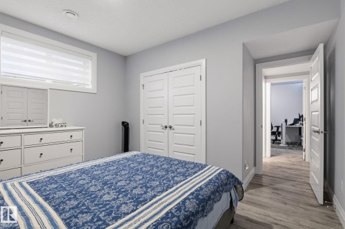 Interior space featuring light gray walls, wood-finish flooring, white trim, and a window with blinds - 731 57 Street Sw, Edmonton, AB - Indoor Photo Showing Bedroom