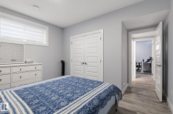 Interior space featuring light gray walls, wood-finish flooring, white trim, and a window with blinds - 