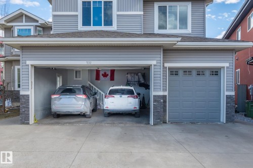 Grey siding exterior featuring a multi-car garage with a closed panel door - 731 57 Street Sw, Edmonton, AB - Outdoor