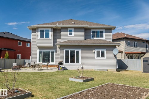 Expansive backyard featuring a concrete patio, a manicured lawn, and raised garden beds - 731 57 Street Sw, Edmonton, AB - Outdoor