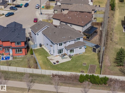 Expansive backyard featuring a large concrete patio, lush green lawn, raised garden beds, and a storage shed - 731 57 Street Sw, Edmonton, AB - Outdoor