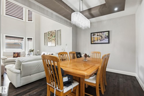 Formal dining area featuring a tiered ceiling with recessed lighting and a crystal chandelier - 731 57 Street Sw, Edmonton, AB - Indoor Photo Showing Dining Room