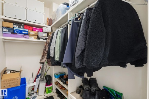 Walk-in closet featuring white built-in shelving, hanging rods, and an integrated shoe rack - 731 57 Street Sw, Edmonton, AB - Indoor With Storage