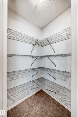 Corner pantry featuring multiple levels of wire shelving and diagonal tile flooring - 6723 19 Avenue, Edmonton, AB 