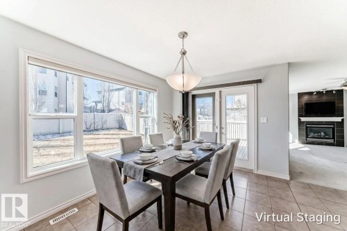 Dining area featuring tile flooring, a multi-pane window, and a door to an exterior deck - 6723 19 Avenue, Edmonton, AB 