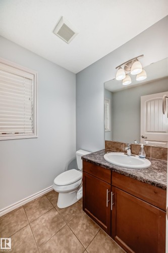 Vanity with a surface-mounted sink, a laminate countertop, and a tiled backsplash - 6723 19 Avenue, Edmonton, AB 