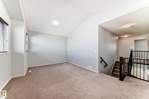 Carpeted upper-level bonus room with vaulted ceilings and recessed lighting - 6723 19 Avenue, Edmonton, AB 