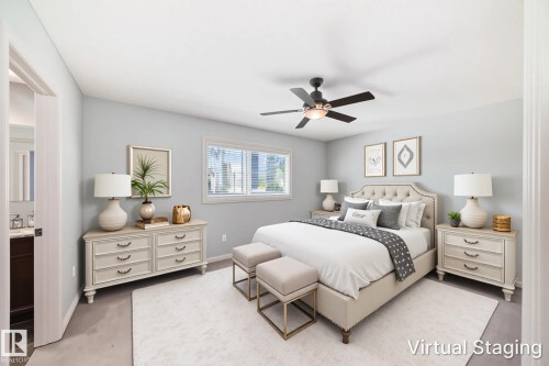 Spacious room featuring a contemporary ceiling fan with integrated lighting, a large window, light-colored walls, and a doorway revealing a partial view of a bathroom vanity with a dark wood-finish base and light countertop - 6723 19 Avenue, Edmonton, AB 