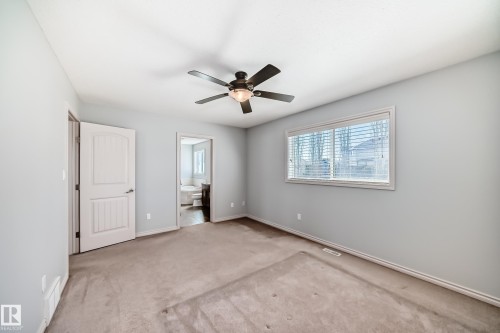 Carpeted room featuring a ceiling fan with integrated lighting, a window with horizontal blinds, and two paneled doors - 6723 19 Avenue, Edmonton, AB 