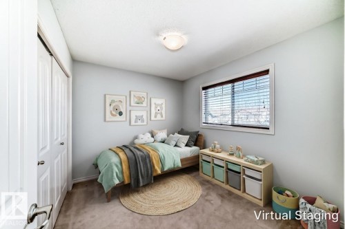 Carpeted room featuring a white bi-fold closet, light-toned walls, and a window with horizontal blinds - 6723 19 Avenue, Edmonton, AB 