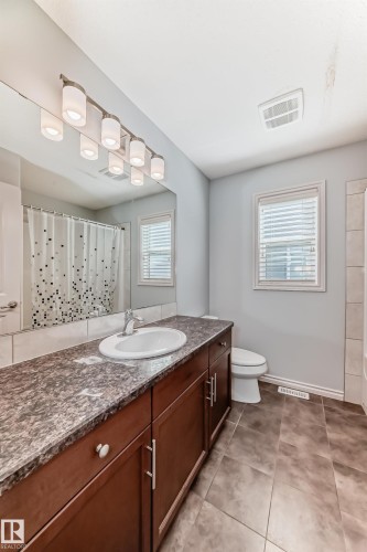 Long vanity with an integrated sink, granite-look countertop, and substantial storage cabinetry - 6723 19 Avenue, Edmonton, AB 