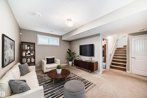 Carpeted living area featuring a single window, recessed lighting, and a neutral color palette - 6723 19 Avenue, Edmonton, AB 