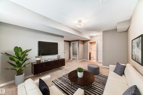 Carpeted living area featuring recessed lighting, painted walls, and a visible doorway to an additional room - 6723 19 Avenue, Edmonton, AB 