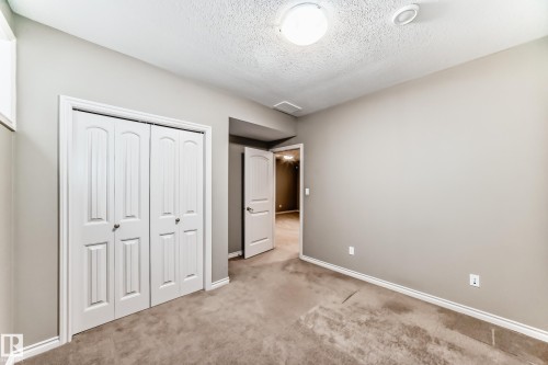 Room with neutral-toned walls, carpet flooring, a ceiling-mounted light fixture, and white bi-fold closet doors - 6723 19 Avenue, Edmonton, AB 