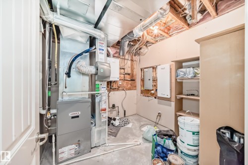 Utility room featuring a Lennox furnace, exposed ceiling joists, and built-in shelving - 6723 19 Avenue, Edmonton, AB 