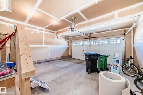 Concrete flooring garage with an automatic overhead door featuring transom windows - 6723 19 Avenue, Edmonton, AB 