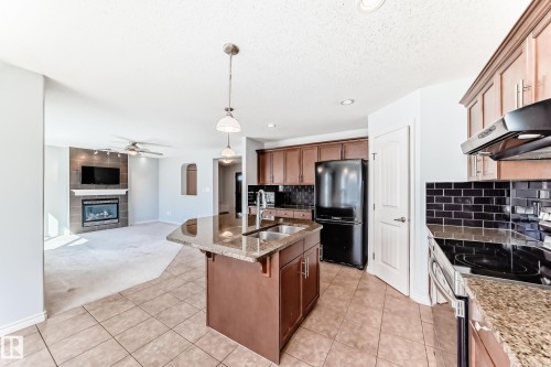 Kitchen island with granite countertop, double basin sink, and pendant lighting - 6723 19 Avenue, Edmonton, AB 