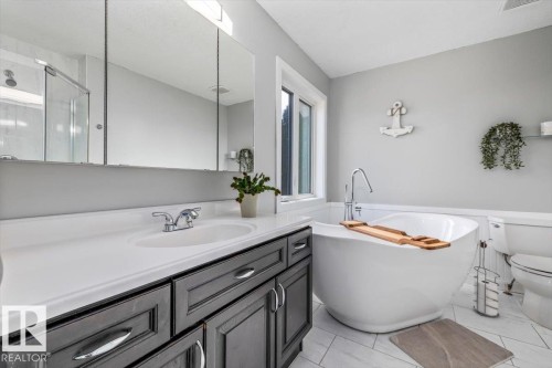 Bathroom featuring a contemporary freestanding soaking tub with a floor-mounted faucet - 86 Westpark Way, Fort Saskatchewan, AB - Indoor Photo Showing Bathroom