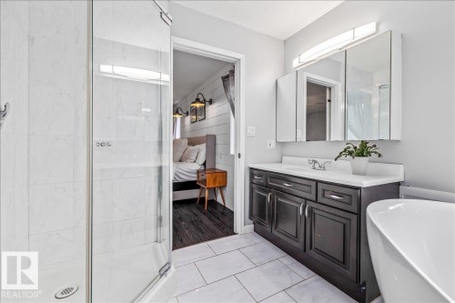 Contemporary bathroom featuring a dark wood-finish vanity with a white countertop and dual medicine cabinets - 86 Westpark Way, Fort Saskatchewan, AB - Indoor Photo Showing Bathroom