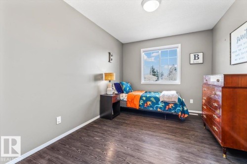 Room featuring gray walls, wood-finish flooring, and a single window with white trim - 86 Westpark Way, Fort Saskatchewan, AB - Indoor Photo Showing Bedroom
