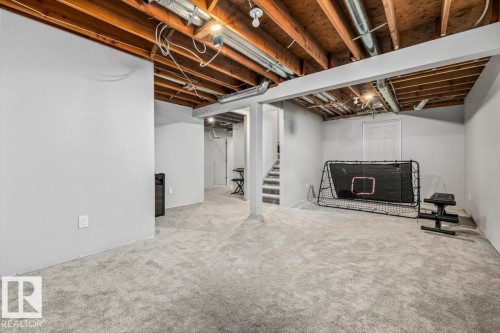 Finished lower level featuring light gray carpeting, neutral painted walls, exposed ceiling joists, and recessed lighting - 86 Westpark Way, Fort Saskatchewan, AB - Indoor Photo Showing Basement