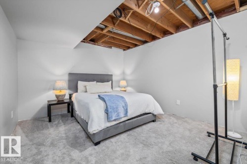 Lower level room featuring light gray carpeting, exposed ceiling joists, and painted walls - 86 Westpark Way, Fort Saskatchewan, AB - Indoor Photo Showing Bedroom