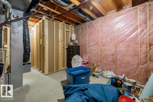 Unfinished basement area featuring exposed wood framing, concrete flooring, pink insulation, and visible HVAC ductwork - 86 Westpark Way, Fort Saskatchewan, AB - Indoor Photo Showing Basement
