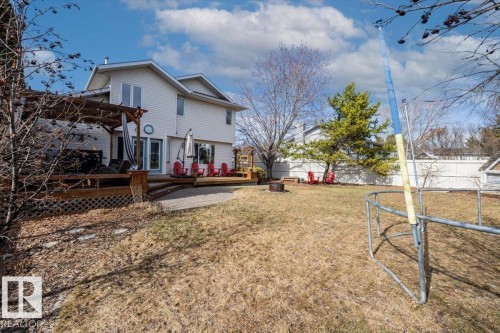 Spacious backyard featuring a multi-level wood deck, a pergola, and a fire pit area - 86 Westpark Way, Fort Saskatchewan, AB - Outdoor With Deck Patio Veranda